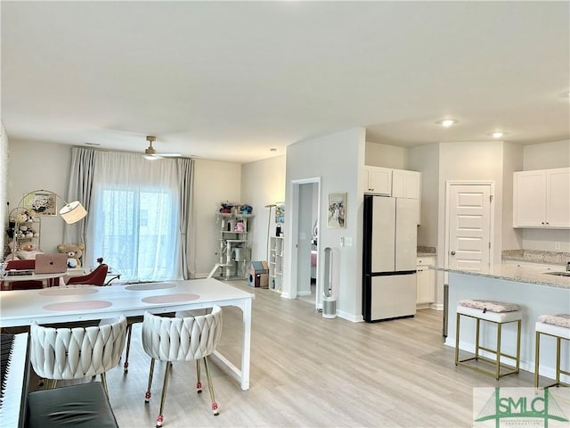 dining room featuring baseboards, a ceiling fan, light wood-style flooring, and recessed lighting