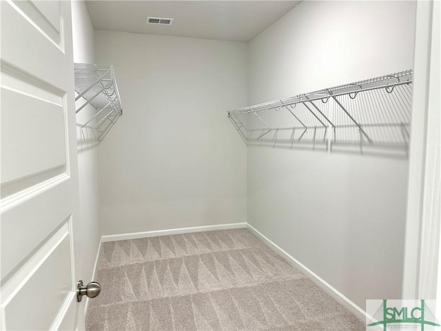 walk in closet with visible vents and carpet