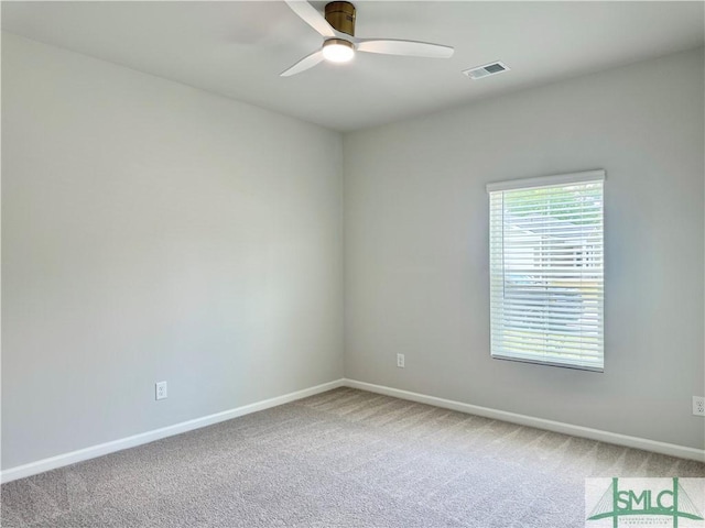 carpeted spare room featuring baseboards, a ceiling fan, and visible vents