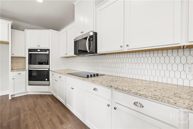 31 Oakmont Dr, Guyton, GA 31312 - kitchen featuring stainless steel double oven, black electric stovetop, decorative backsplash, lofted ceiling, and white cabinets