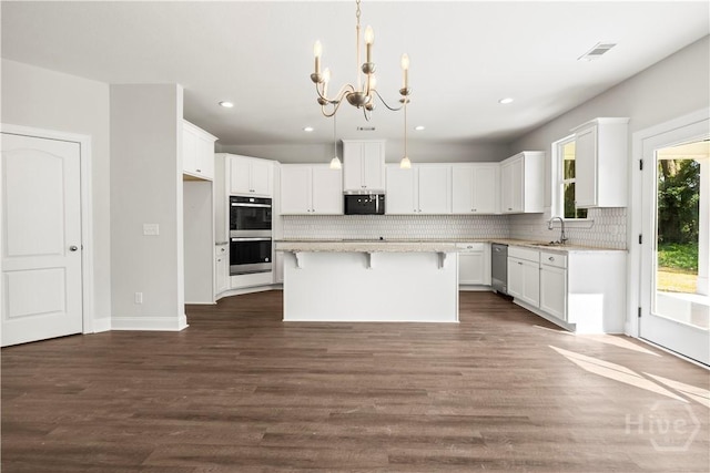 31 Oakmont Dr, Guyton, GA 31312 - kitchen with appliances with stainless steel finishes, a chandelier, recessed lighting, decorative backsplash, and a kitchen island