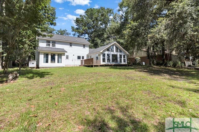 back of house featuring a wooden deck and a yard