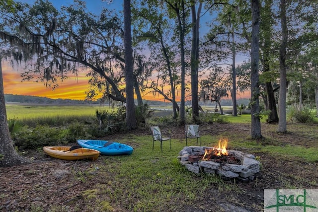 yard at dusk featuring an outdoor fire pit