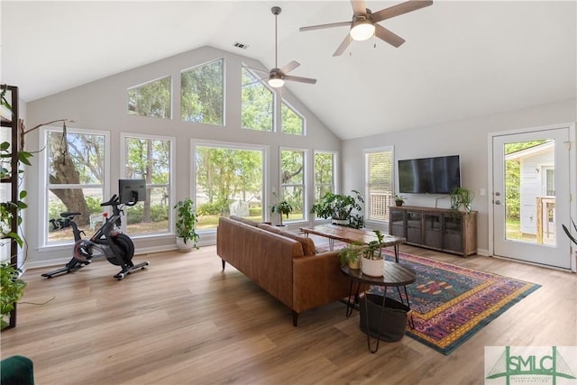 living room with light wood-type flooring, visible vents, high vaulted ceiling, and ceiling fan