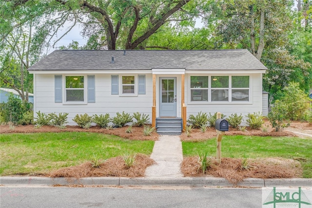 ranch-style house with a front lawn and a shingled roof
