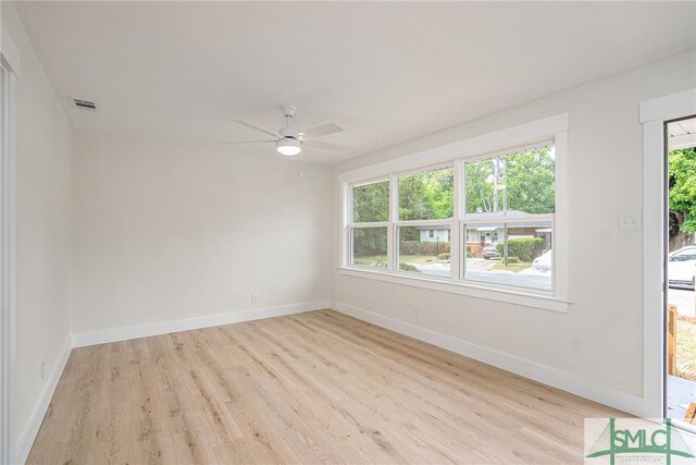 empty room featuring baseboards, a ceiling fan, wood finished floors, and visible vents