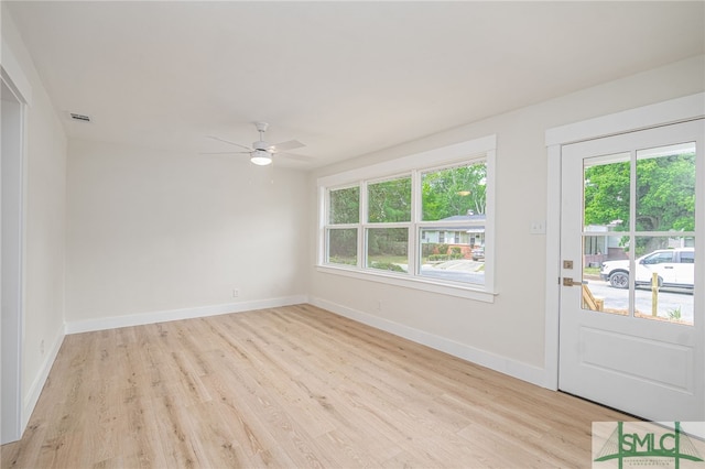spare room featuring light wood-style floors, visible vents, baseboards, and ceiling fan