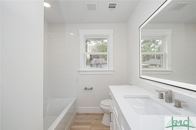 bathroom with wood finished floors, visible vents, and a wealth of natural light