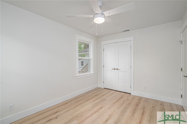 unfurnished bedroom featuring baseboards, wood finished floors, visible vents, and ceiling fan