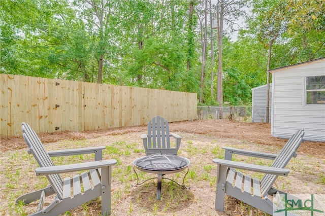view of yard with a fenced backyard and an outdoor fire pit