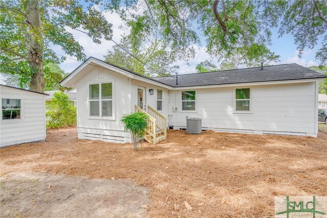 rear view of house with roof with shingles and central AC unit