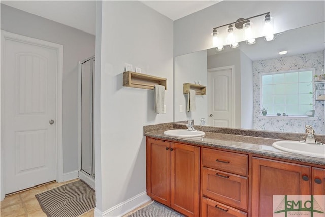 bathroom with a sink, a shower stall, and double vanity