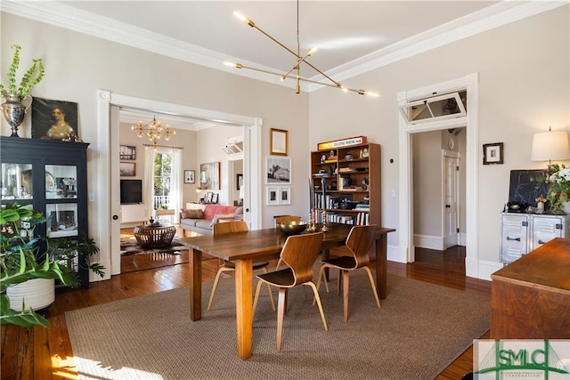 dining area featuring ornamental molding, wood finished floors, and a chandelier