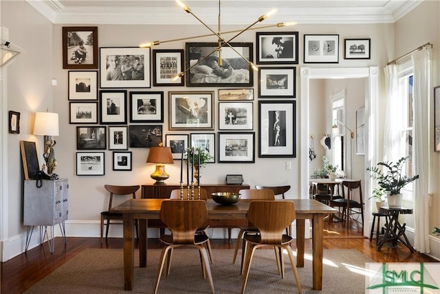 dining room with wood finished floors, crown molding, and baseboards