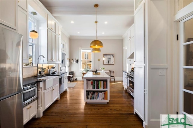 kitchen featuring a center island, a sink, under cabinet range hood, stainless steel appliances, and dark wood-style flooring