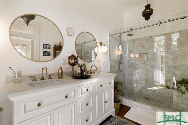 full bath featuring double vanity, a stall shower, and a sink