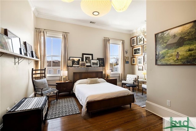 bedroom featuring visible vents, baseboards, ornamental molding, and wood-type flooring
