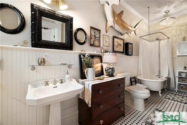 bathroom featuring toilet, a wainscoted wall, a shower with shower curtain, and a bathing tub