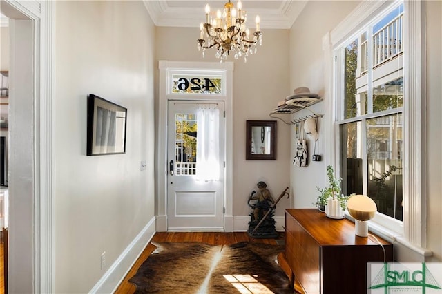 doorway with plenty of natural light, wood finished floors, a chandelier, and ornamental molding