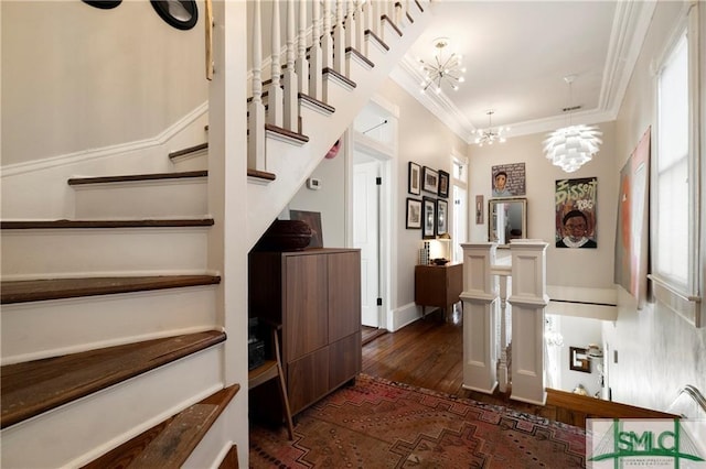 stairway featuring wood finished floors, a notable chandelier, and ornamental molding