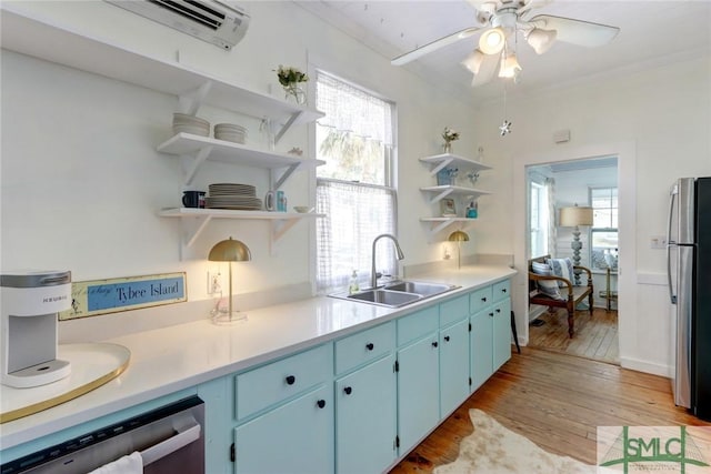 kitchen featuring stainless steel appliances, a sink, light wood-style floors, blue cabinetry, and open shelves