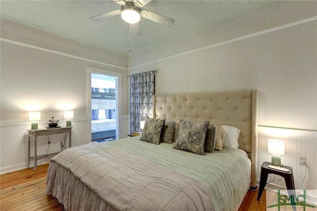 bedroom featuring wainscoting, a ceiling fan, and hardwood / wood-style floors