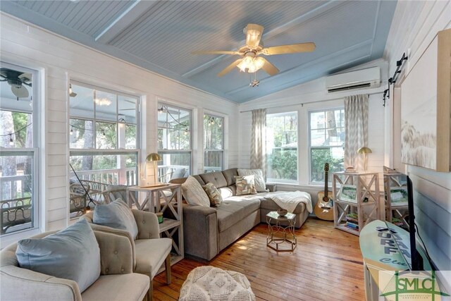 sunroom with wood-type flooring, plenty of natural light, an AC wall unit, and lofted ceiling with beams