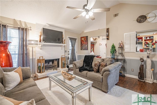 living area with a ceiling fan, visible vents, wood finished floors, and vaulted ceiling