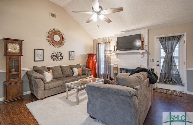 living area with visible vents, wood finished floors, lofted ceiling, baseboards, and ceiling fan
