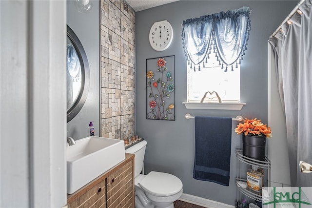 bathroom featuring vanity, a textured ceiling, and toilet