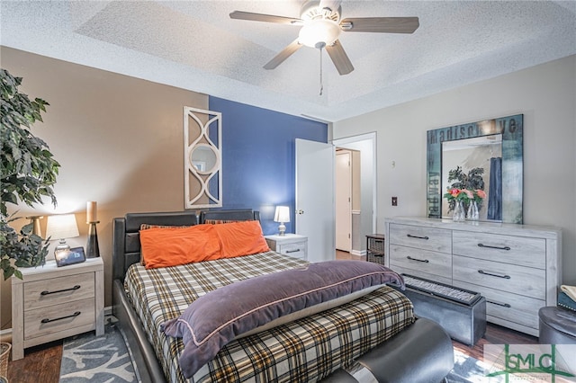 bedroom with a textured ceiling, ceiling fan, and wood finished floors
