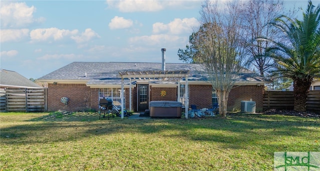 back of house with fence, a pergola, cooling unit, a hot tub, and a yard