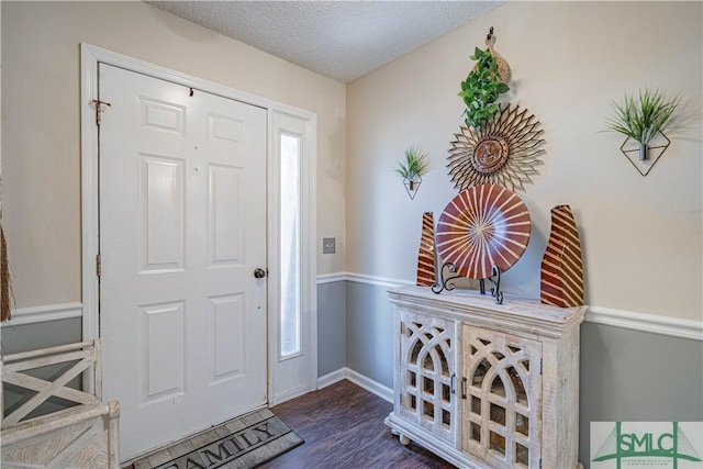 entrance foyer featuring baseboards, a textured ceiling, and dark wood finished floors