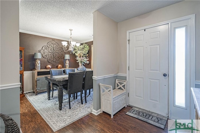 dining area featuring a textured ceiling, an inviting chandelier, a wealth of natural light, and wood finished floors
