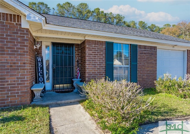 entrance to property with brick siding, an attached garage, and a shingled roof