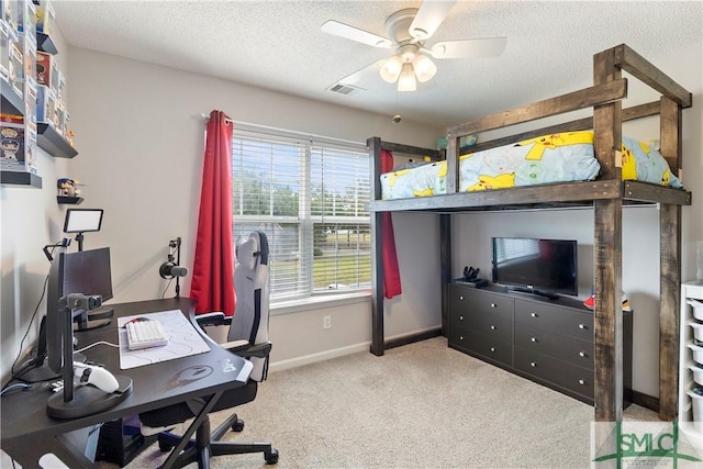 carpeted office space with baseboards, a ceiling fan, a textured ceiling, and visible vents