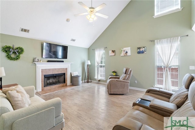 living room featuring high vaulted ceiling, a ceiling fan, light wood finished floors, and visible vents