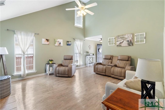 living room featuring high vaulted ceiling, a wealth of natural light, a ceiling fan, and wood finished floors