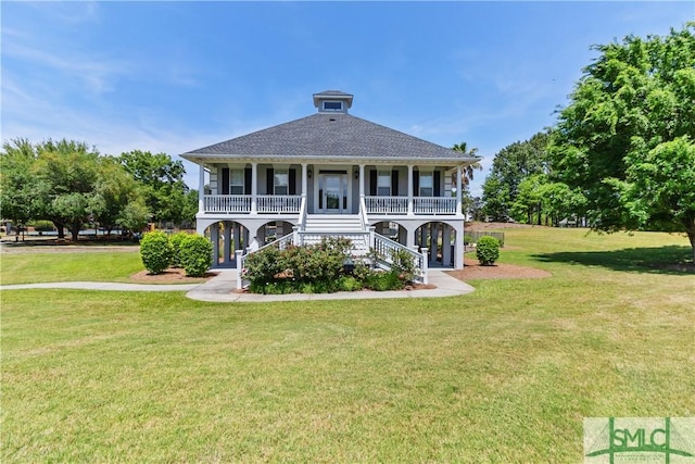back of house with a porch, a shingled roof, stairs, and a lawn