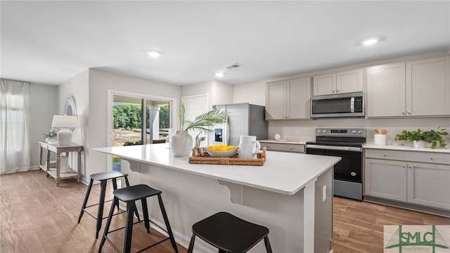 334 Elizabeth Dr, Brunswick, GA 31525 - kitchen with stainless steel appliances, light wood finished floors, a kitchen bar, a center island, and gray cabinetry