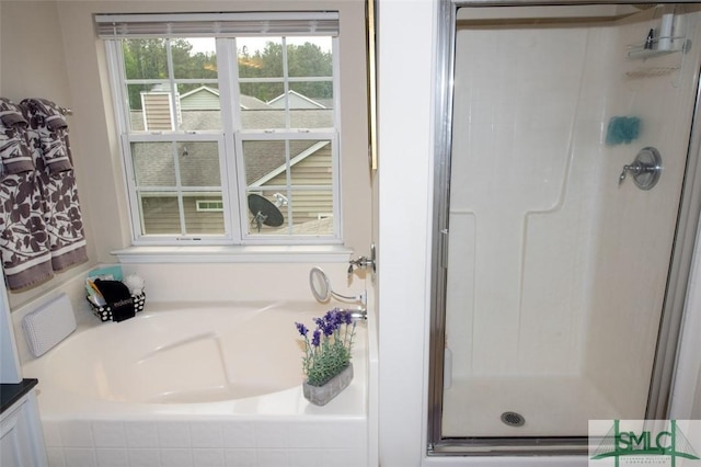 full bathroom featuring a garden tub and a shower stall