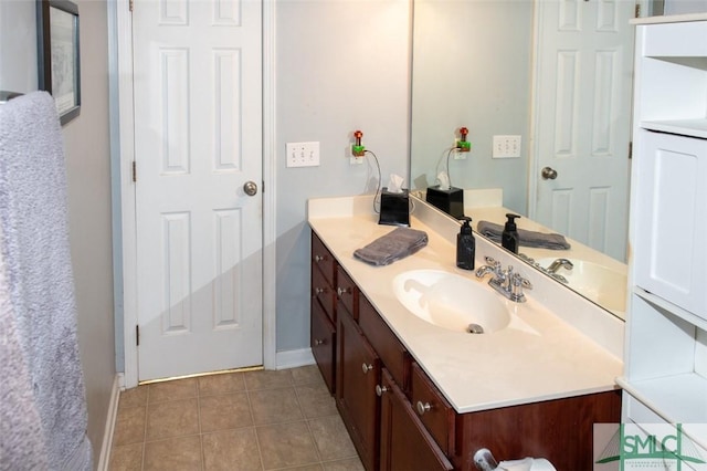 bathroom with baseboards, vanity, and tile patterned floors