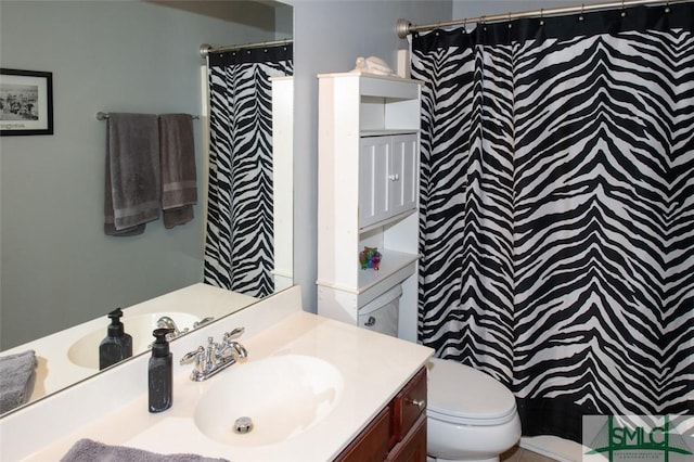 bathroom featuring curtained shower, toilet, and vanity