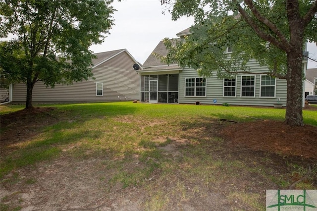 rear view of property with a yard and a sunroom