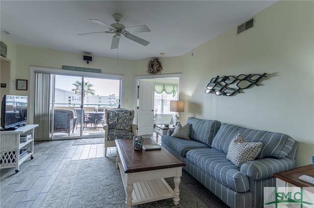 living area featuring wood finished floors, visible vents, and ceiling fan