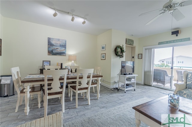 dining space with ceiling fan, baseboards, rail lighting, and light wood-style floors