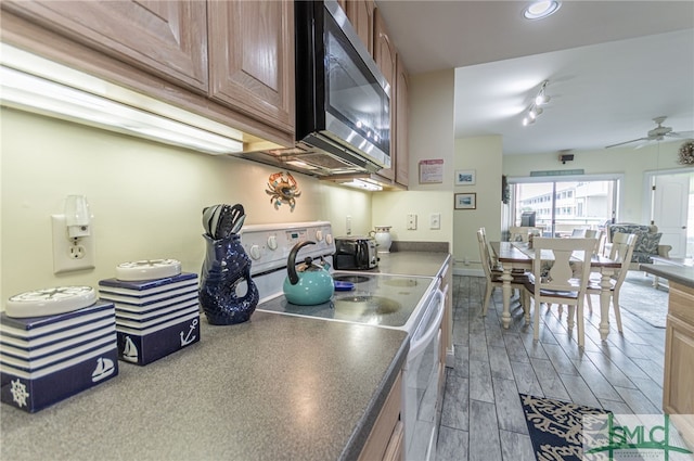 kitchen featuring a ceiling fan, electric stove, wood finished floors, dark countertops, and stainless steel microwave