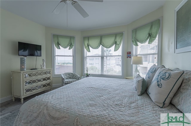 bedroom featuring baseboards, a ceiling fan, and wood finished floors