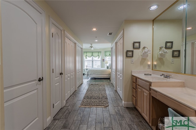 bathroom with ensuite bathroom, wood finished floors, vanity, visible vents, and recessed lighting