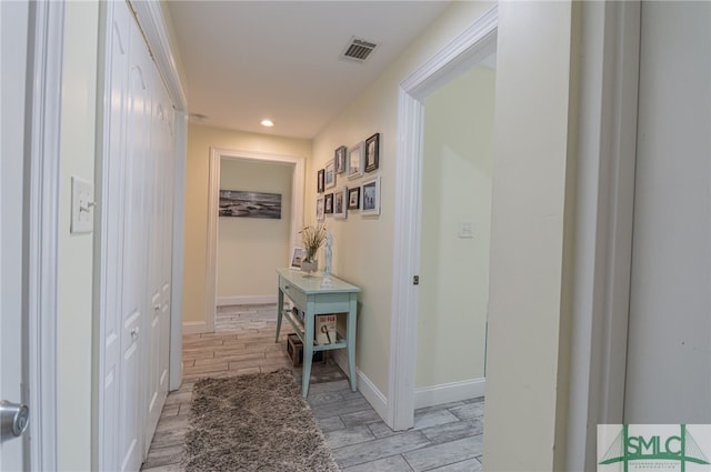 hallway featuring recessed lighting, wood tiled floor, visible vents, and baseboards